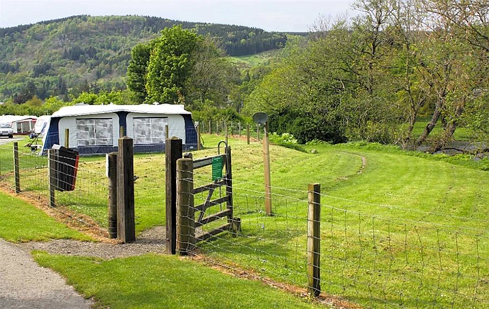 Fenced grass pitch with awning