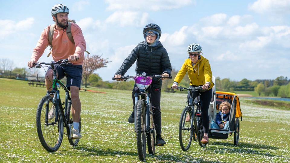 Family cycling by the water