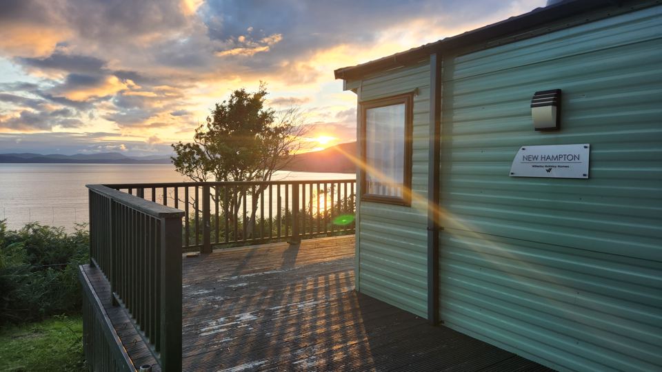Static caravan deck at sunset
