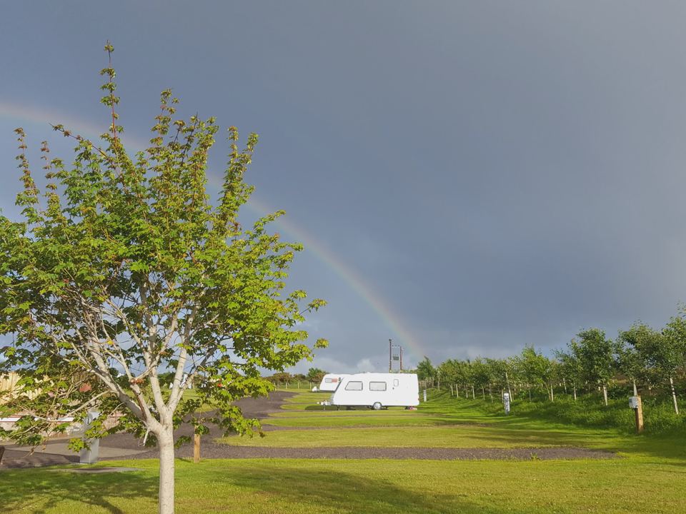 Caravan on a pitch with rainbow