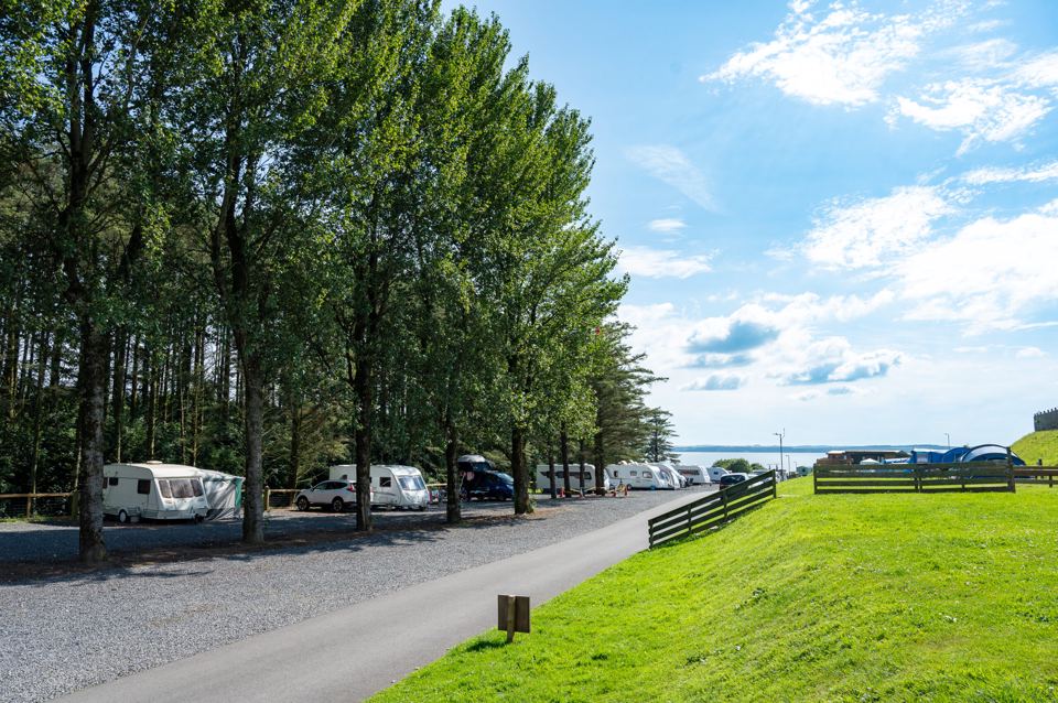 Caravans by the trees above the water