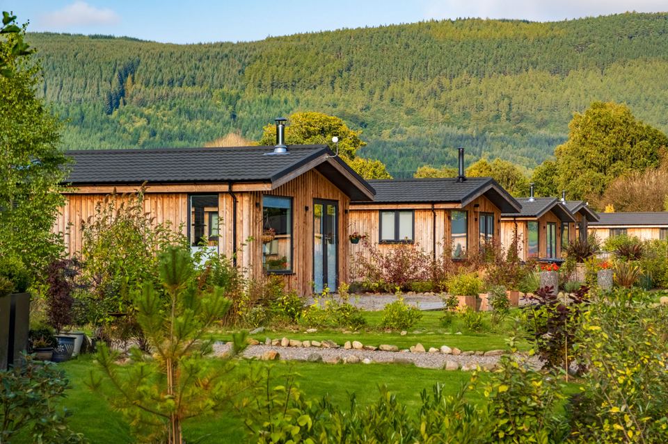 Row of lodges below forested hill