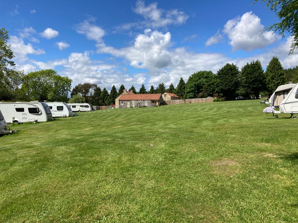 Caravans on the grass towards the farm