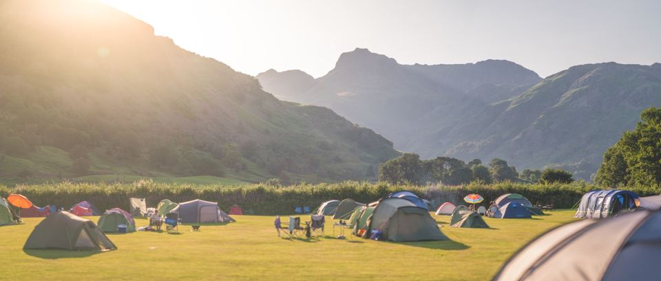 Tents on the field under mountains