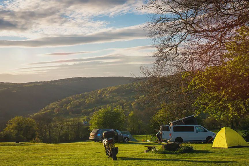 Campervan and tent above the valley