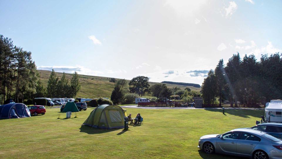 Grass pitches with hills behind