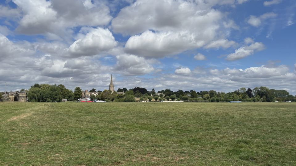 Open grass pitches towards Lechlade spire