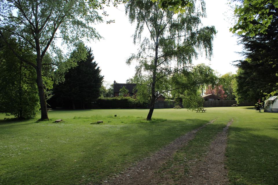 Mown field with a tent in the distance