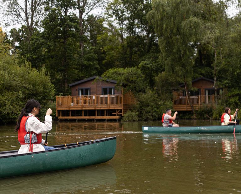 Canoes passing lakeside lodges