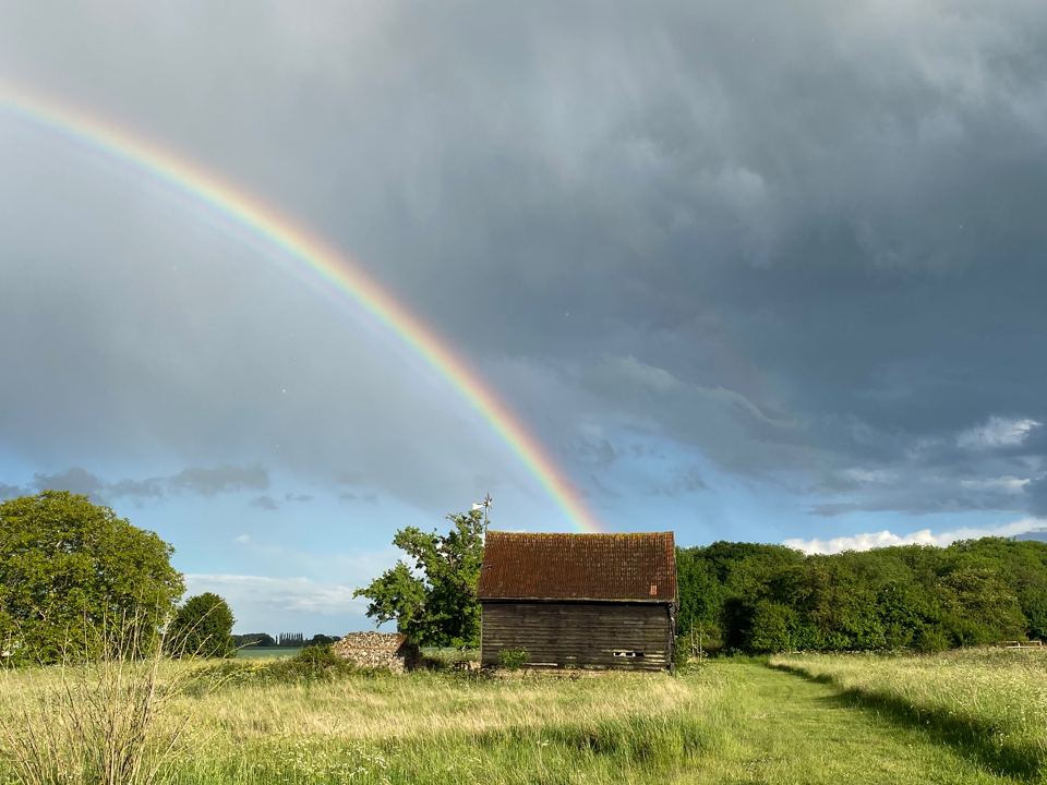 Barn and grass under a rainbow