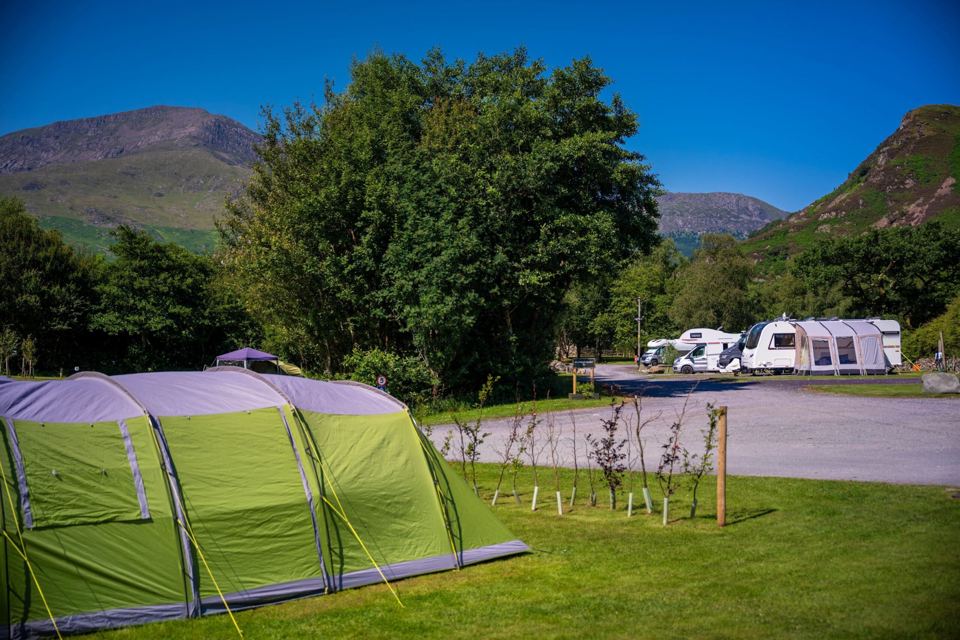 Tent with caravans beyond