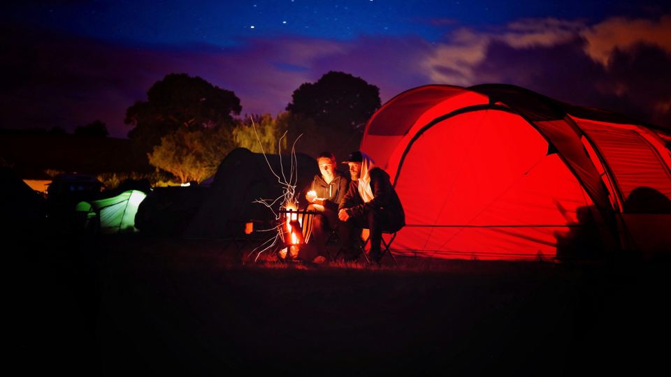 Tents around a campfire at night