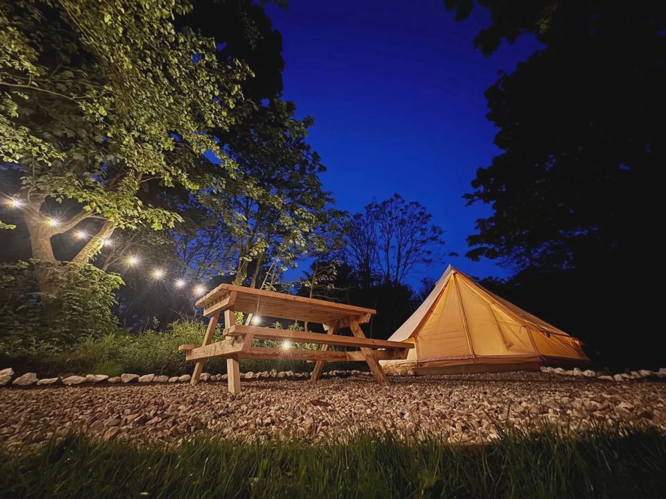 Bell tent and picnic bench at dusk