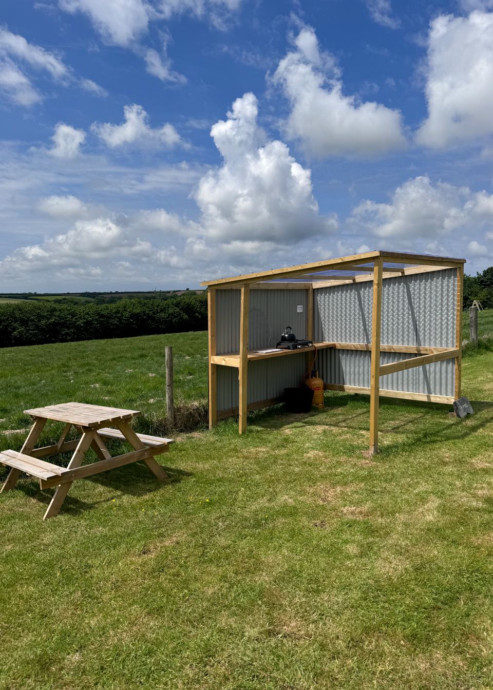 Field with picnic bench and shelter