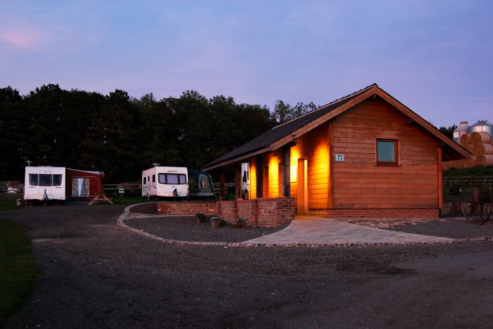 Toilet block and pitches at dusk