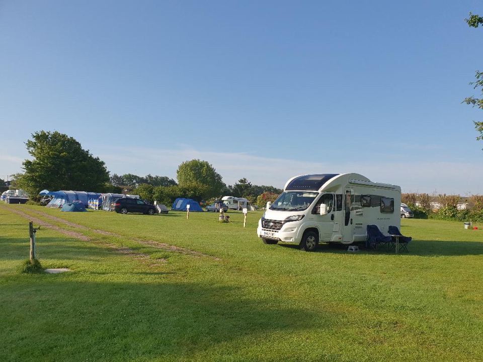 Motorhome and tents on the field