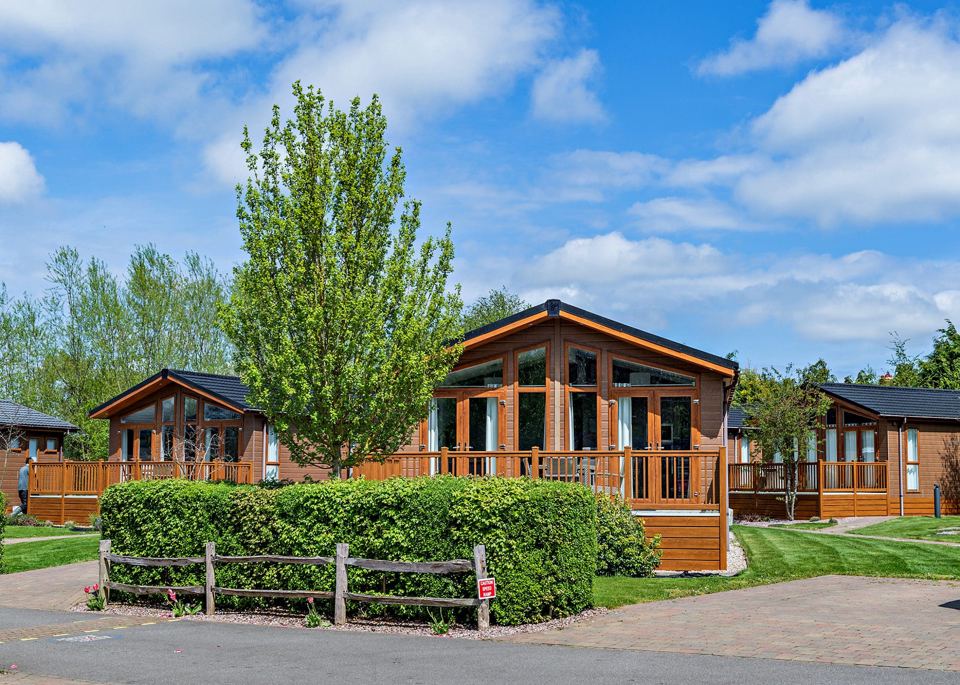 Lodges behind a low hedge