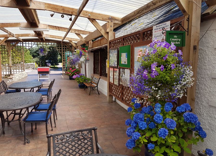 Covered terrace with tables and hanging baskets