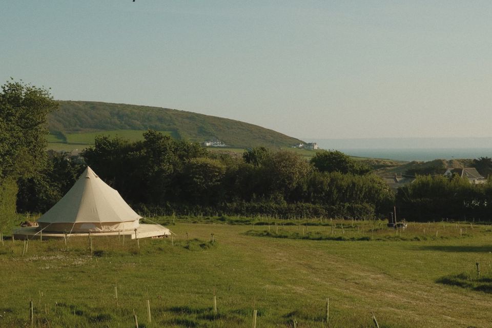 Bell tent in the field with sea view