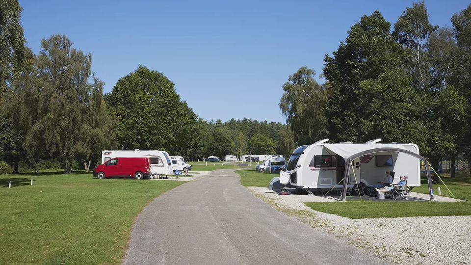 Caravan with awning among trees