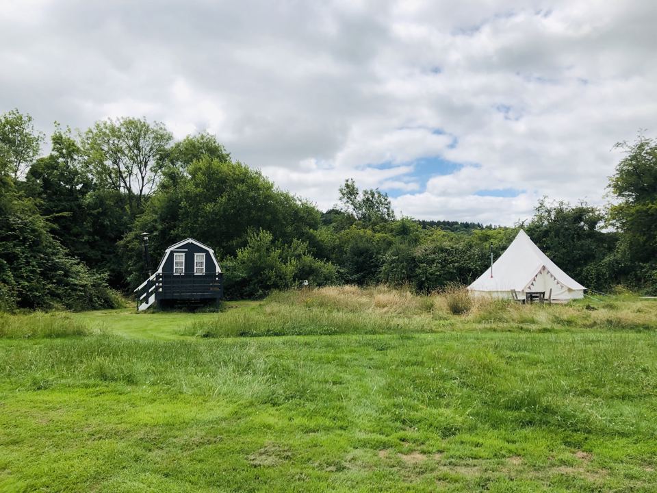 Bell tent and hut in the field