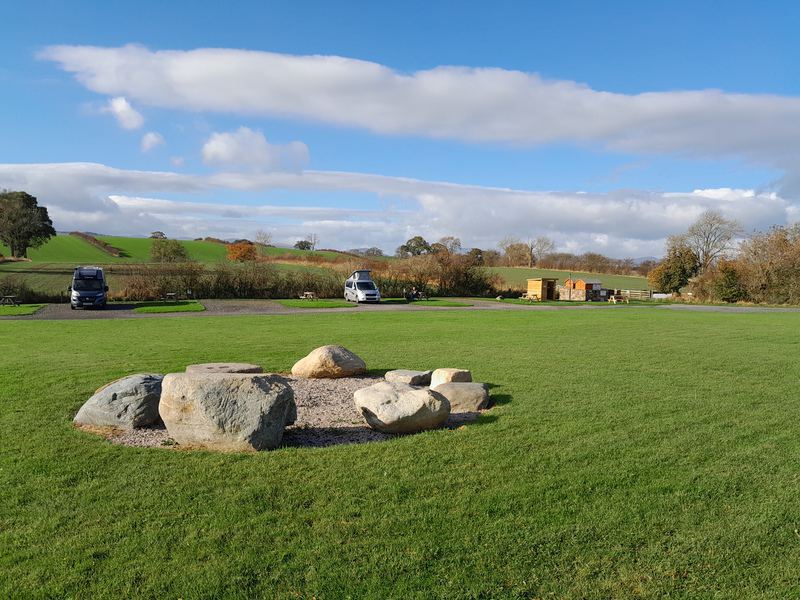 Field with boulders and campervans