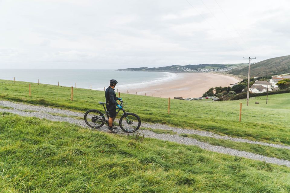Cyclist on the coast path above the beach