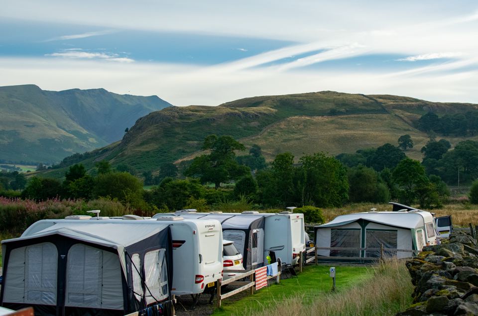 Caravans on pitches with hills behind