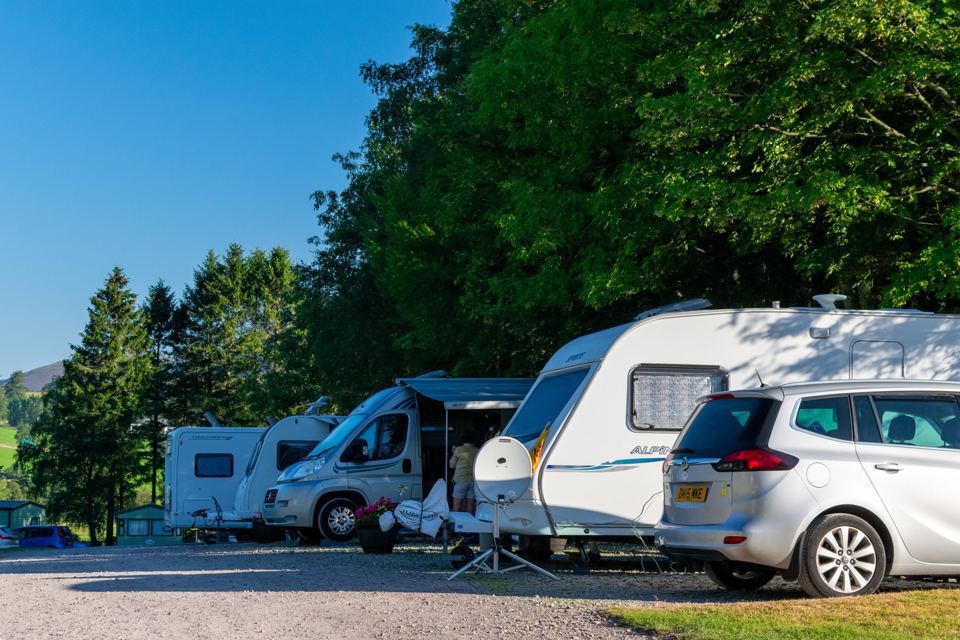 Caravans on gravel pitches under trees