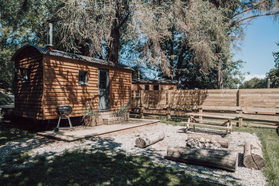 Shepherd's hut beside log fire pit