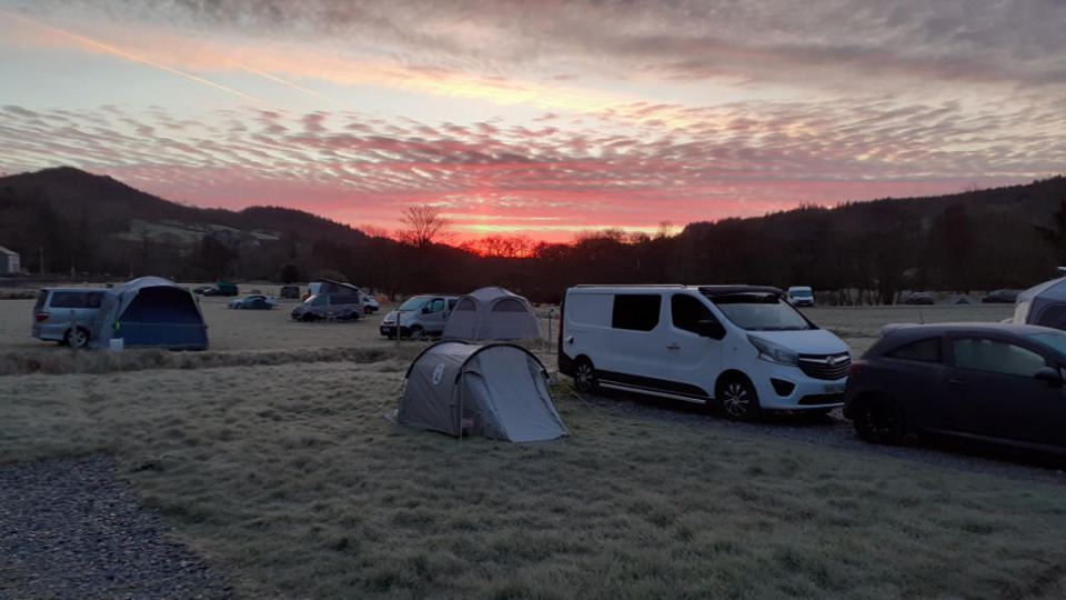 Campervans and tents at sunrise