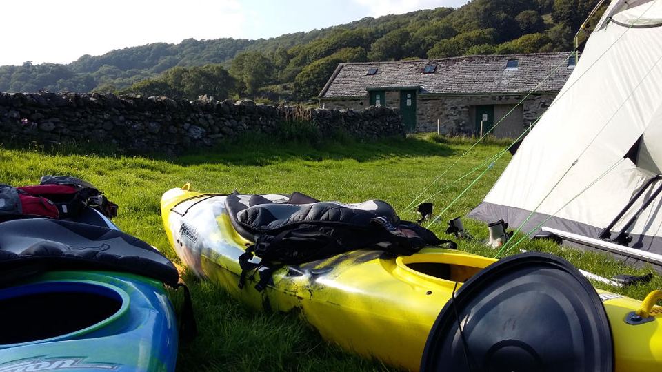 Tent and kayaks beside the barn