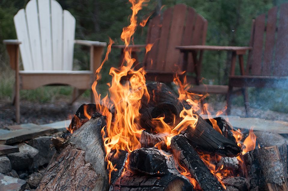 Campfire beside wooden chairs