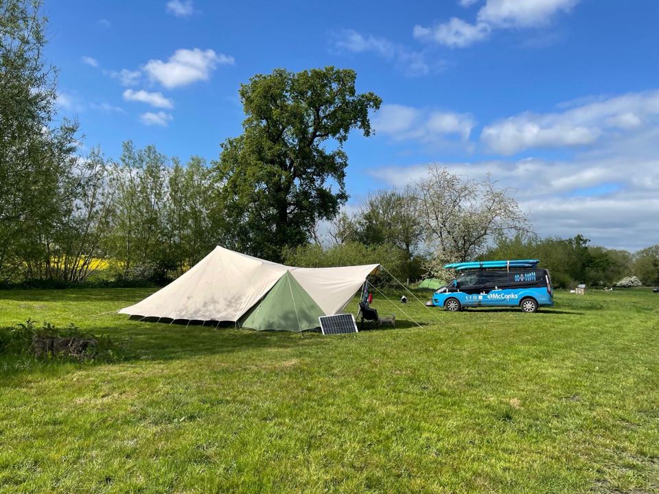 Tent and camper in the meadow