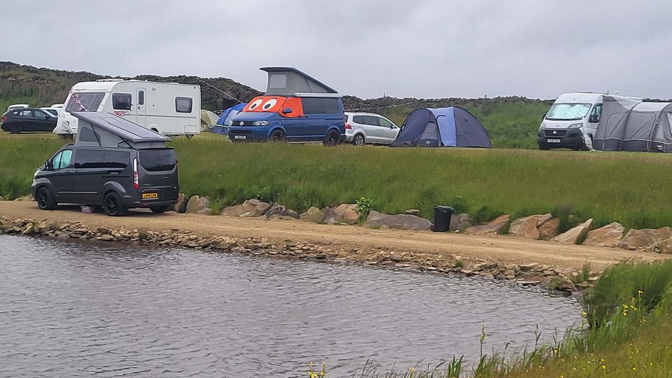 Vans and tents by the lake