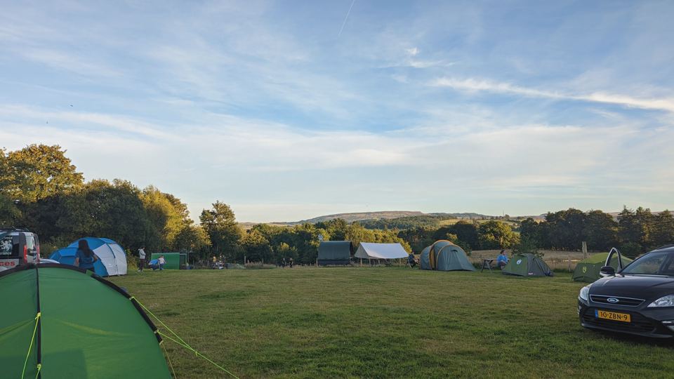 Tent field with hills beyond