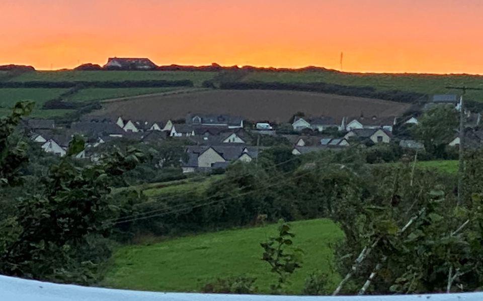 Sunset over village rooftops