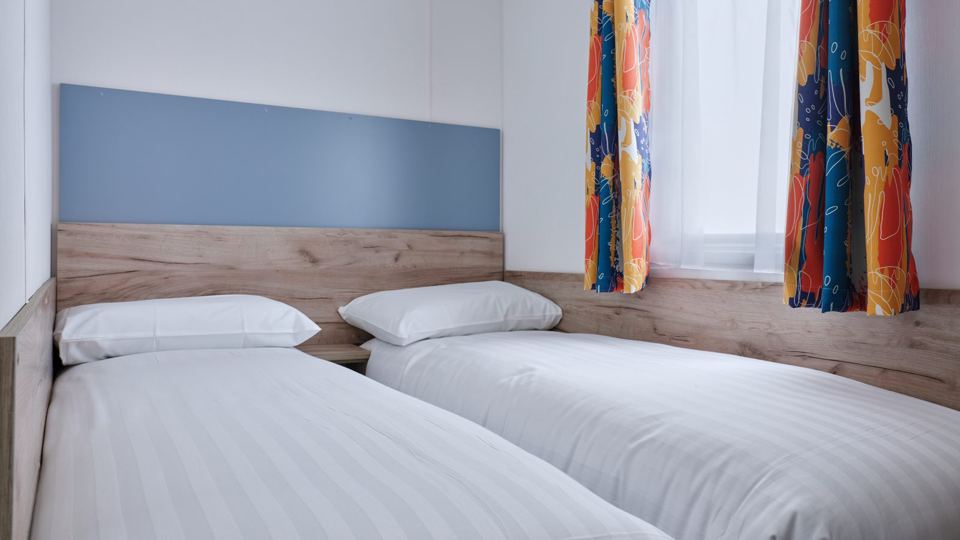 Twin bedroom with orange curtains