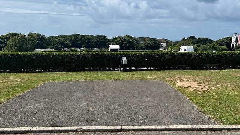 Tarmac pitch behind the hedge