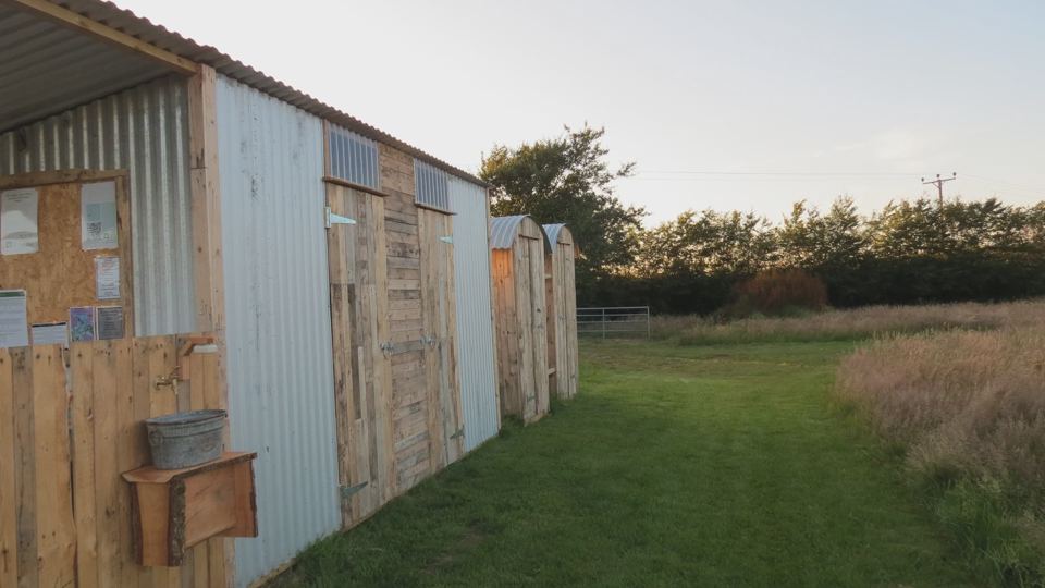 Wooden huts beside a grass path