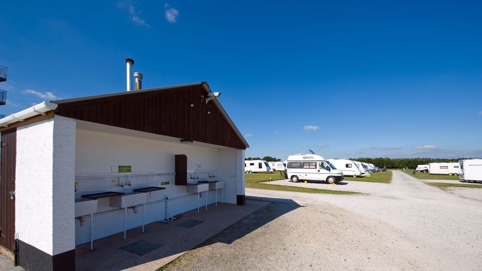 Toilet block with caravans beyond