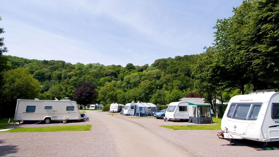 Caravans below wooded slopes