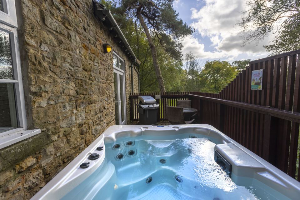 Hot tub by stone cottage