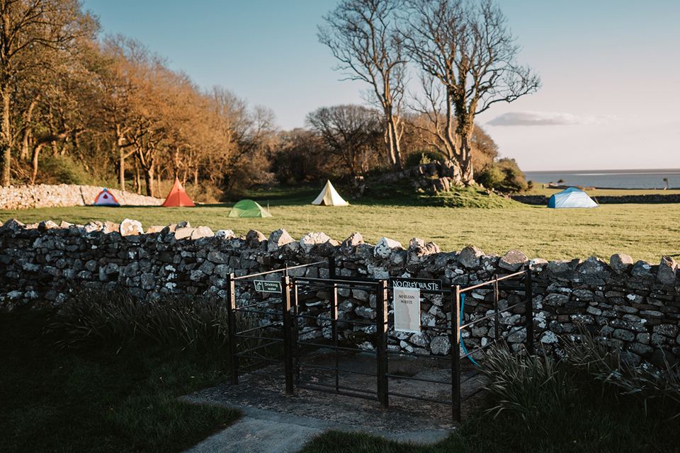 Tent field behind a stone wall