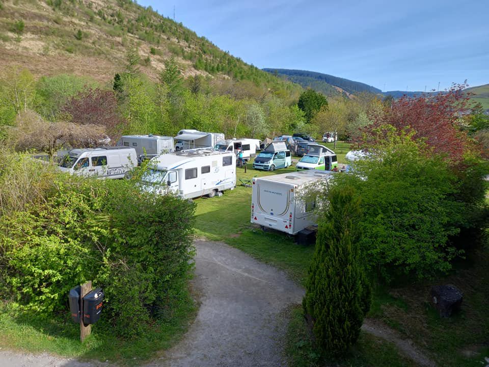 Tourers among shrubs below the hill