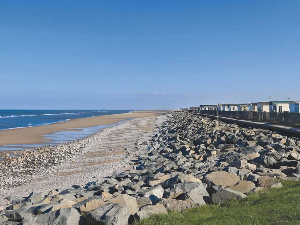 Beach and sea wall with caravans