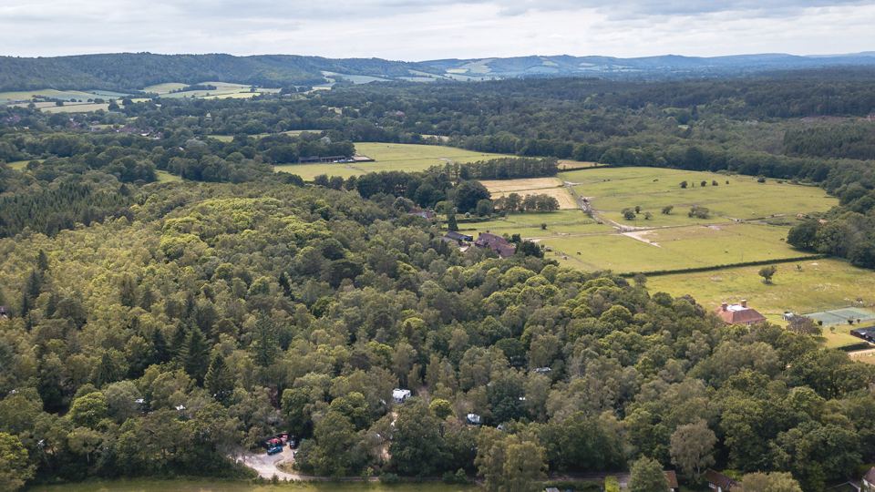 Wooded site and fields from above