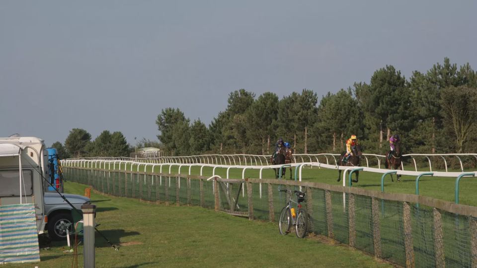 Pitches by the racecourse fence