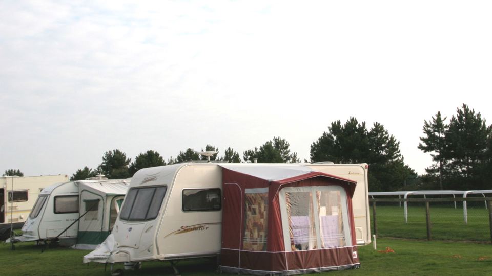 Caravan beside the racecourse rail
