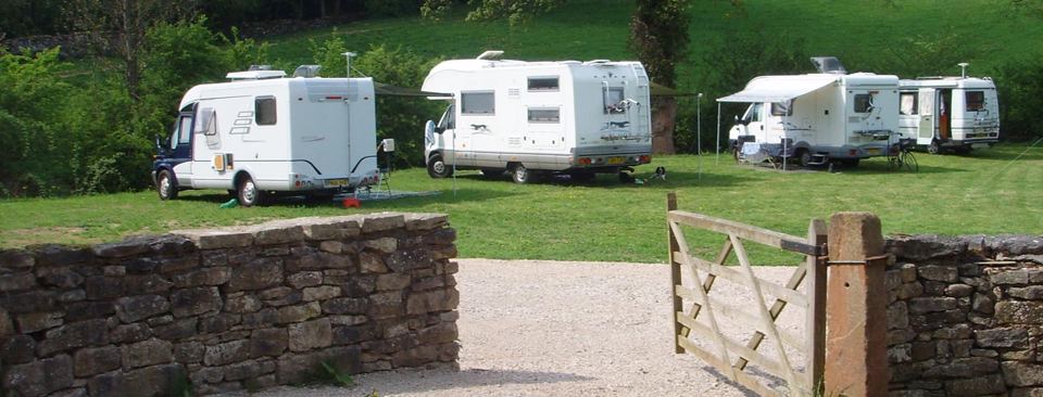 Motorhomes on the grass behind the wall